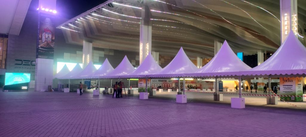 Row of pagoda tents illuminated at night outside an exhibition center - Mahraj Industries UAE